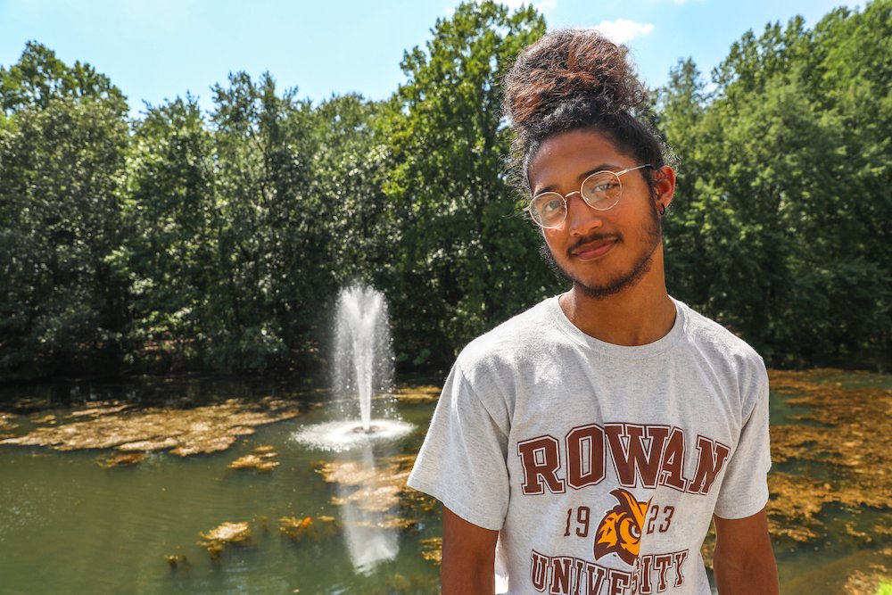 A male student poses in front of engineering hall's pond