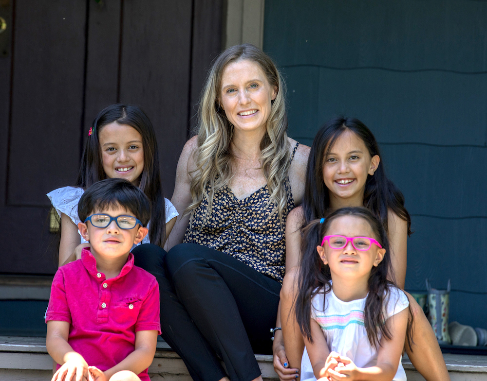 Kerry sits on her porch with her children.