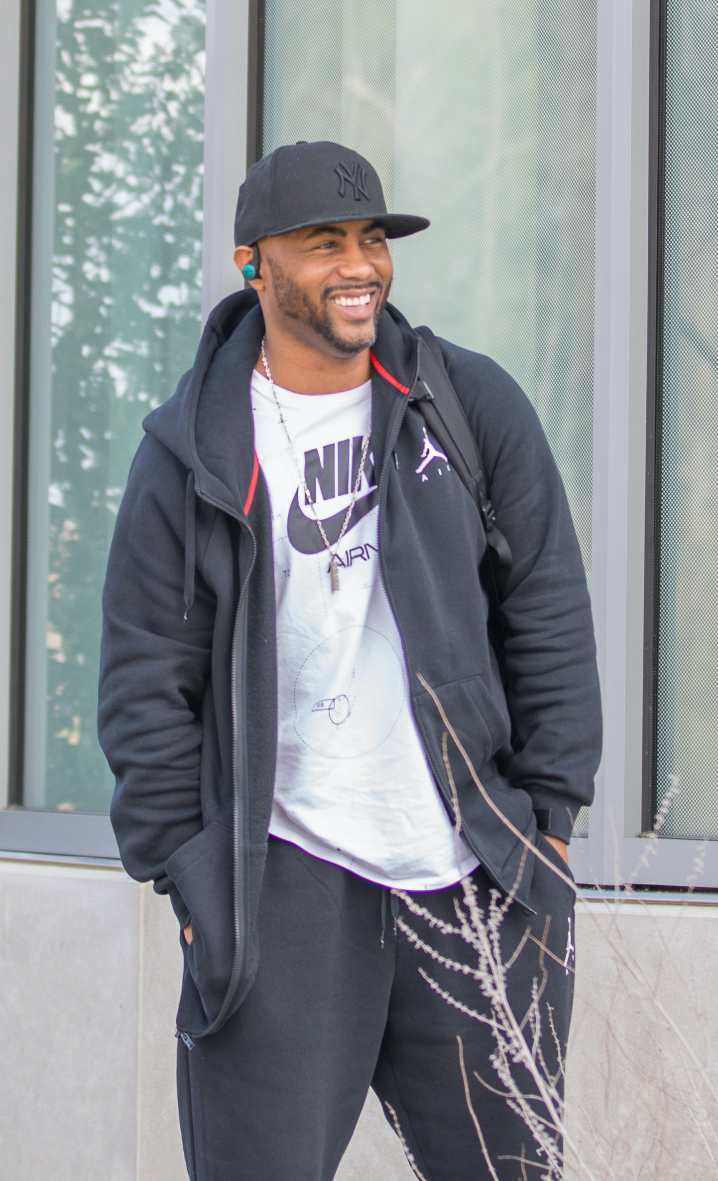 Rasheed smiles looking off to the side, standing outside the Business building.