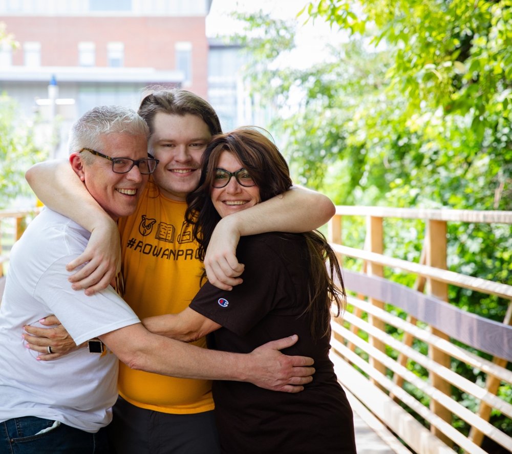 A Rowan University family hugs each other for a photo.