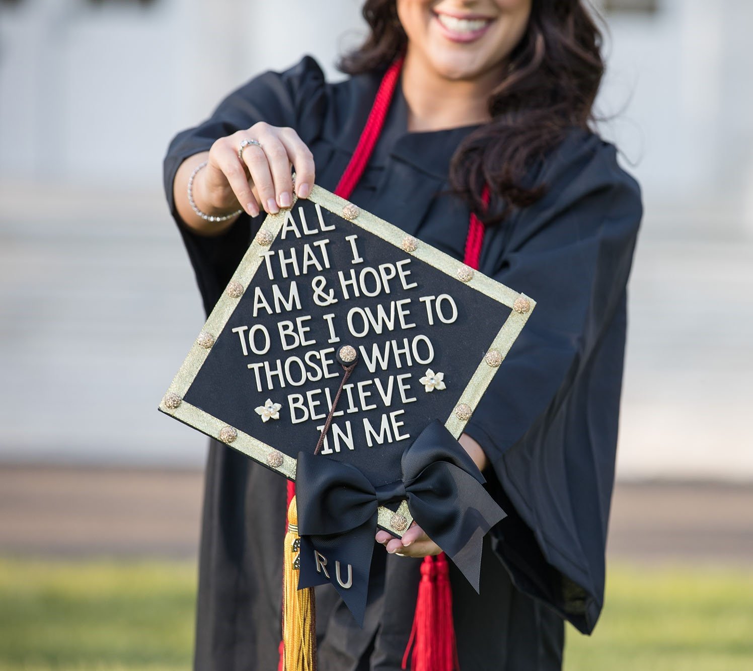 A Rowan University graduate poses for a photo with their graduation cap.