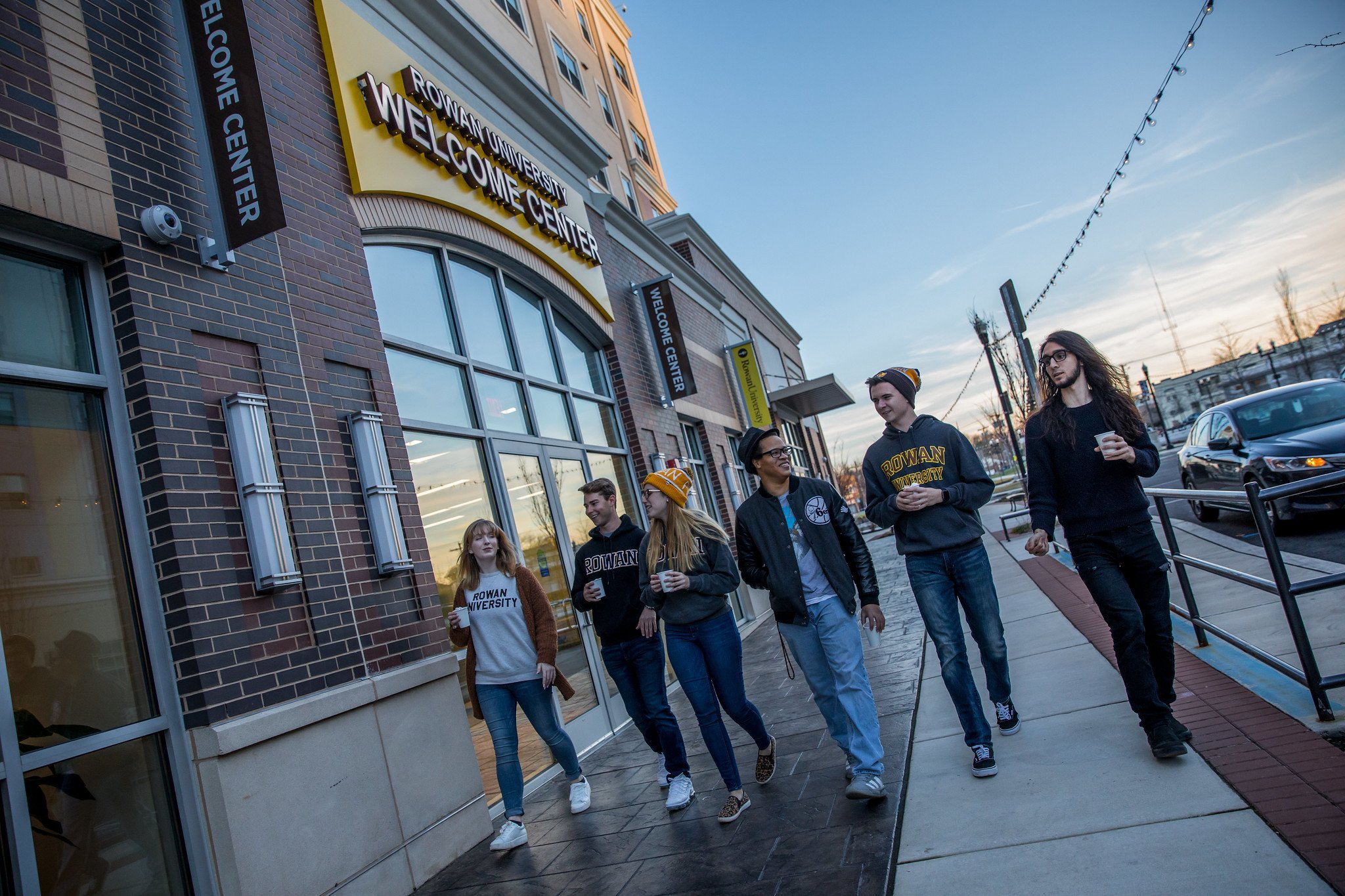 Rowan University students walking past the Welcome Center in winter.
