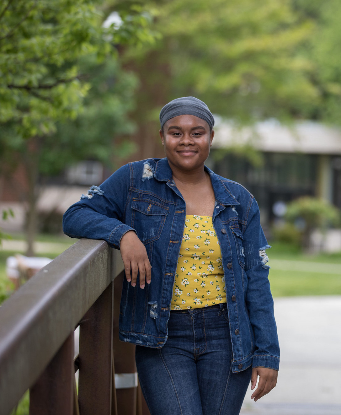 Jahnaya, smiling with her arm leaning over a metal bridge.