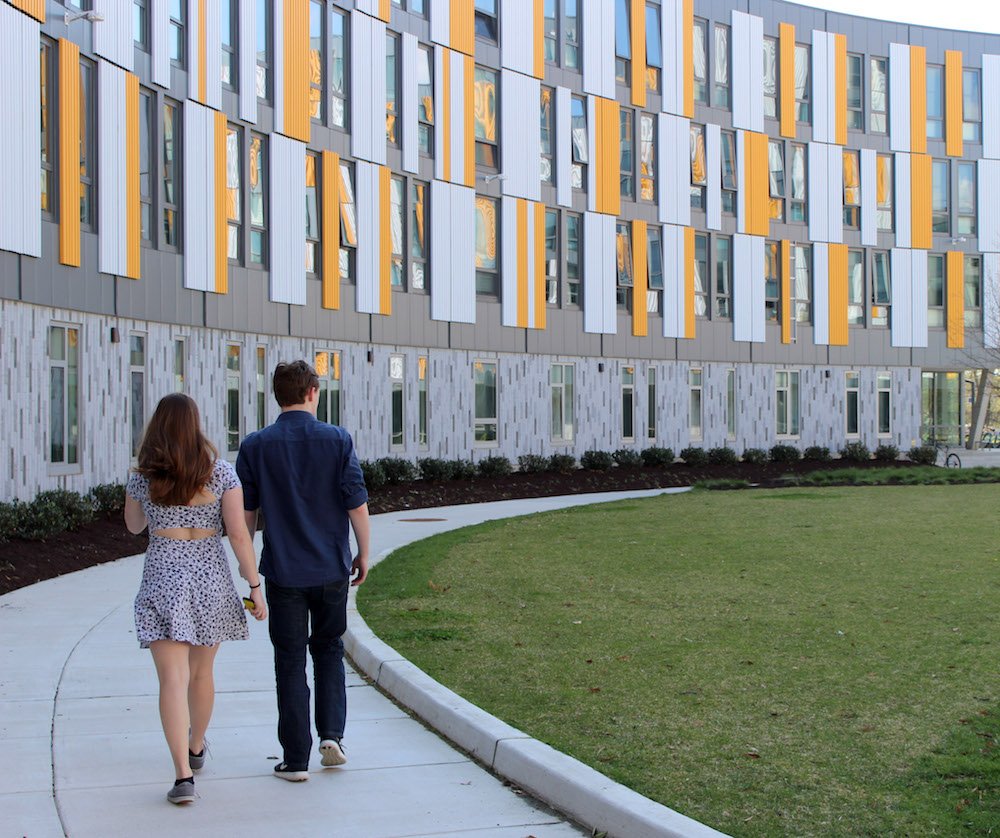 Two students walking next to Holly Pointe Commons.