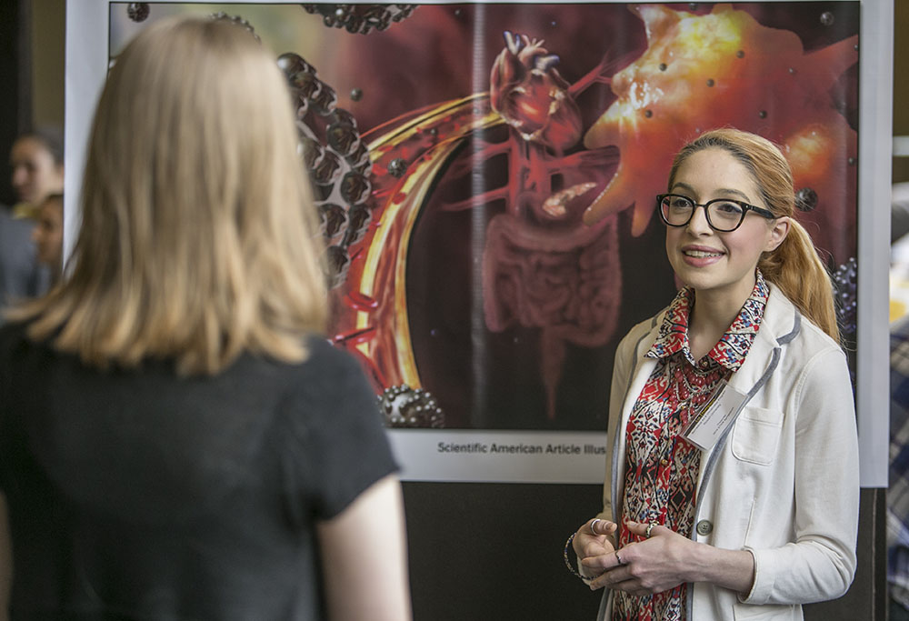 Student showing her art to a spectator