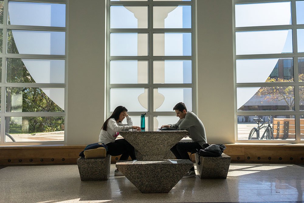 Two students writing at Campbell Library.