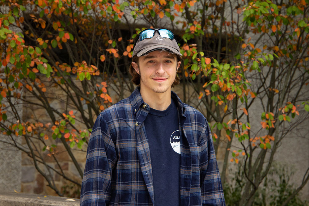 Dominic, standing in front of a bush.