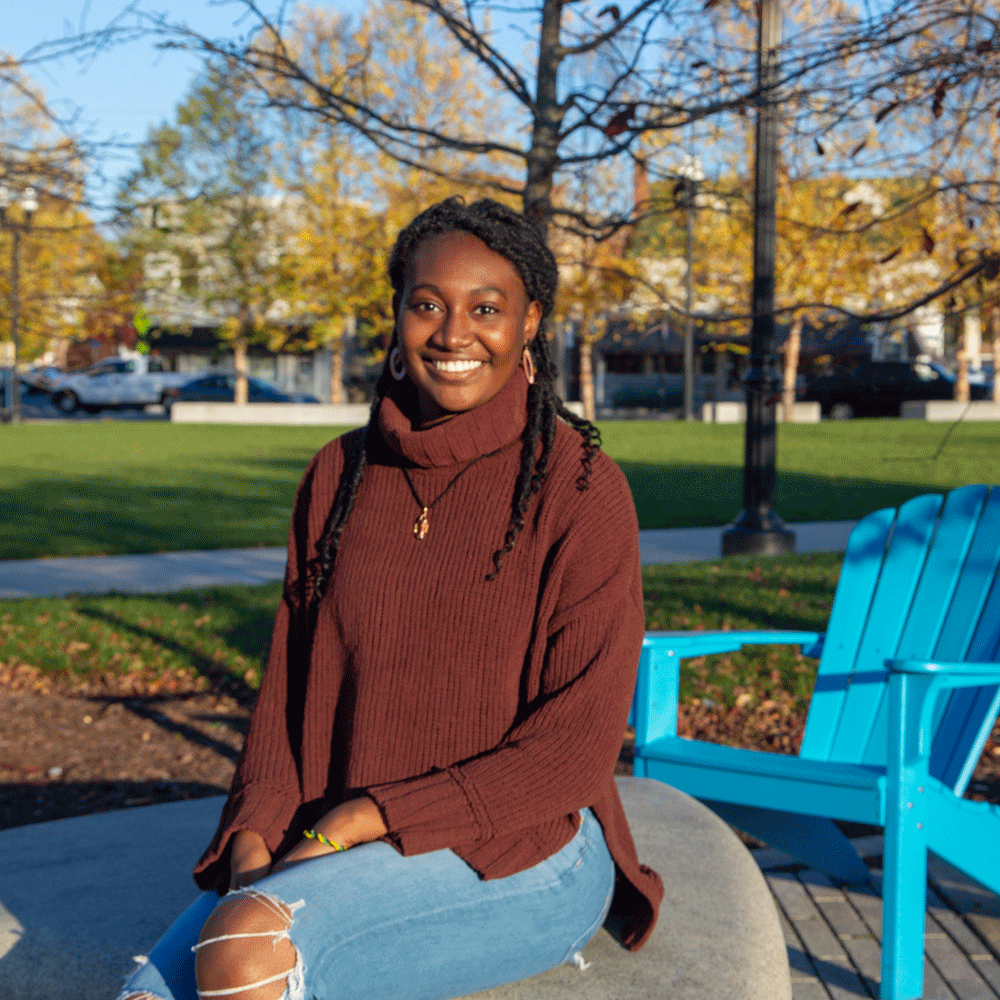 Carolyn smiles and sits outdoors at Rowan Boulevard.