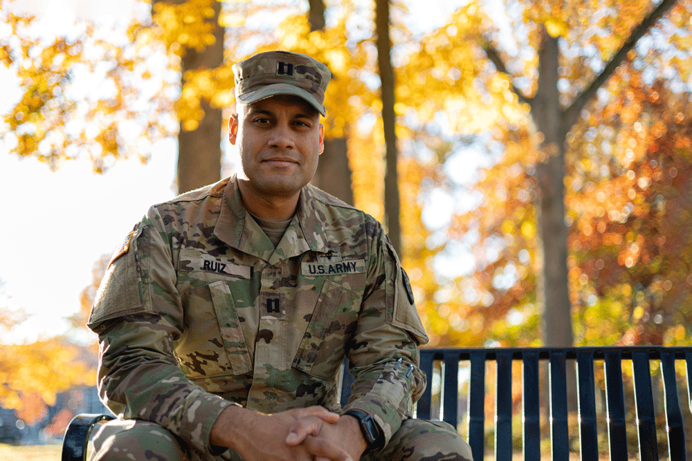 Matt sits on a bench on campus wearing his Army uniform.