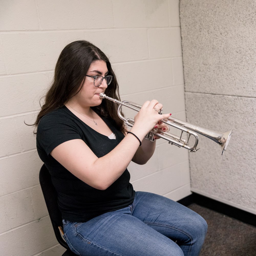Sam practices her instrument inside Wilson Hall.