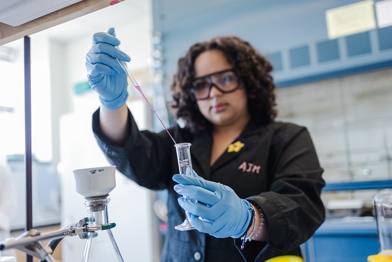 A student holding a beaker up to the camera.