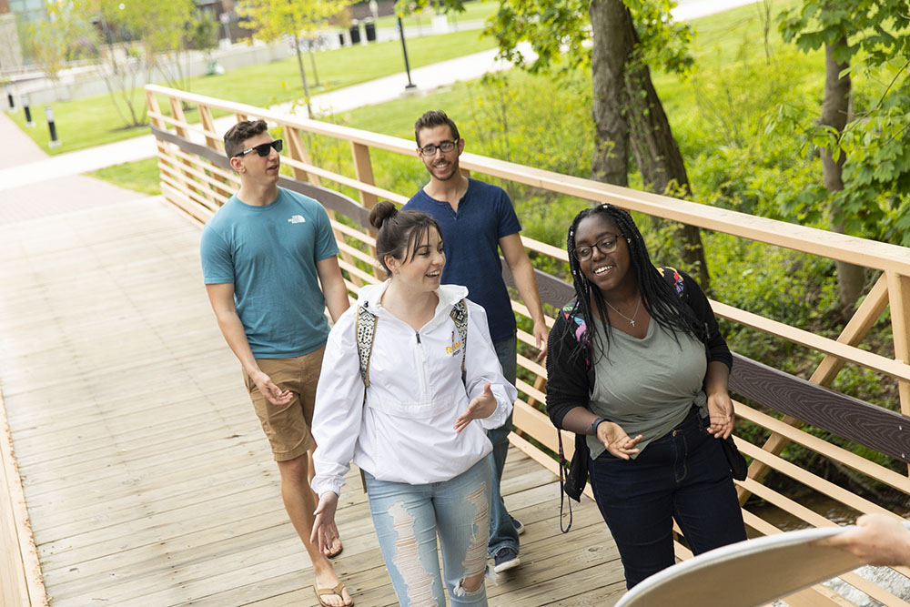 students walking across a bridge.