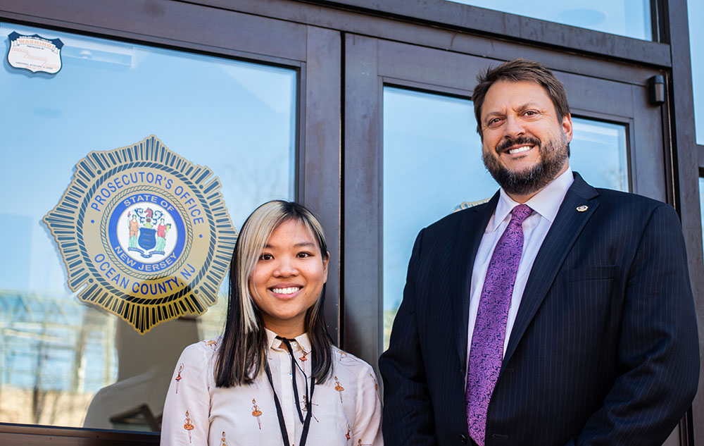 two people smiling outside of a building on campus