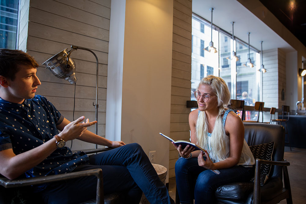 A Rowan University health promotion and wellness management student sits in a cafe working.