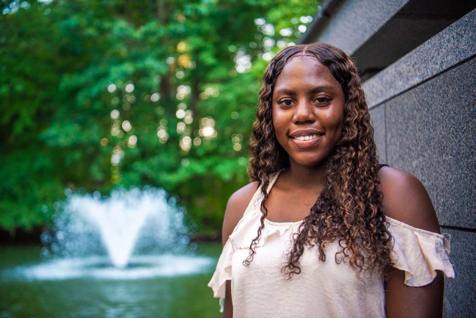 A portrait of Keyanne in front of a fountain.