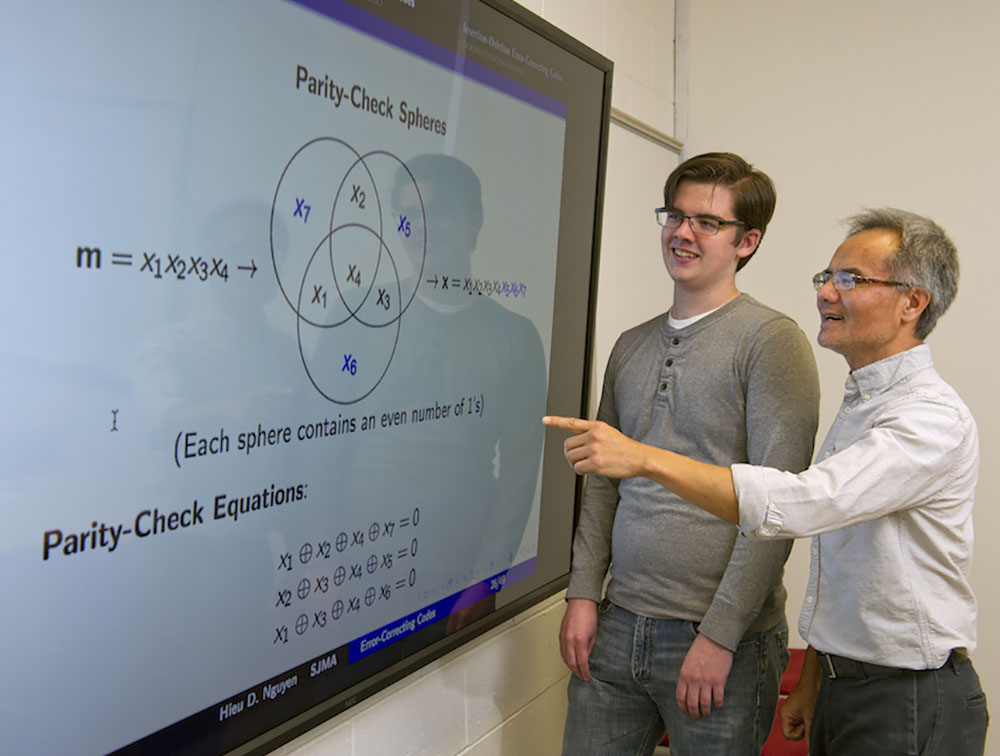 A Rowan University mathematics professor and mathematics major look at a complicated Venn diagram.