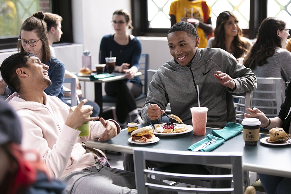 students eating in a cafeteria on campus