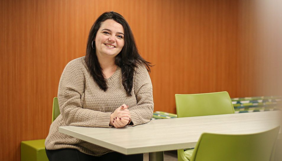 Catherine sits in a collaboration room.