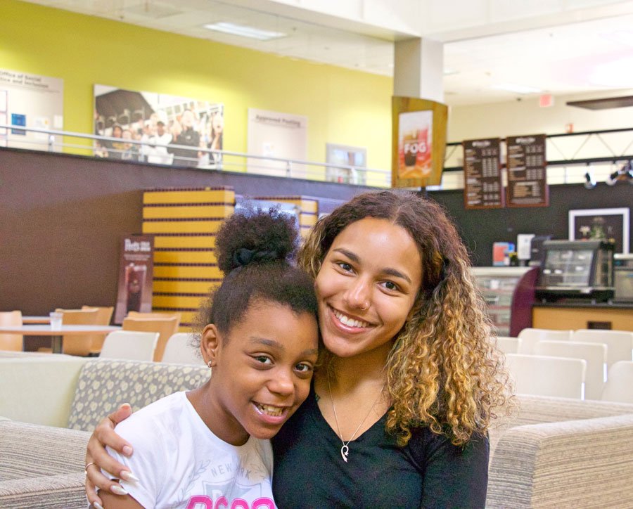 A student and a child hug in the Student Center