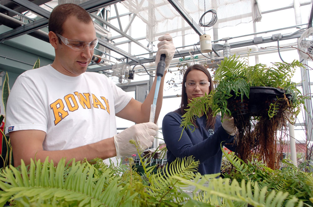 student in laboratory gear, analyzing samples 