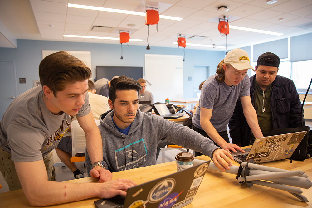 four students collaborating in a classroom.