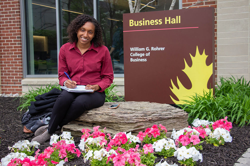 Jo sitting outside of a building on campus.