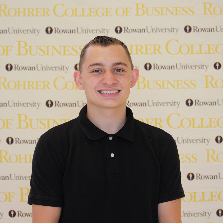 Josh S. standing in front of a College of Business sign