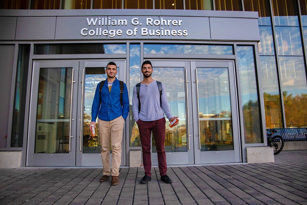 Kayvon J. standing with his business partner outside the doors of Business Hall