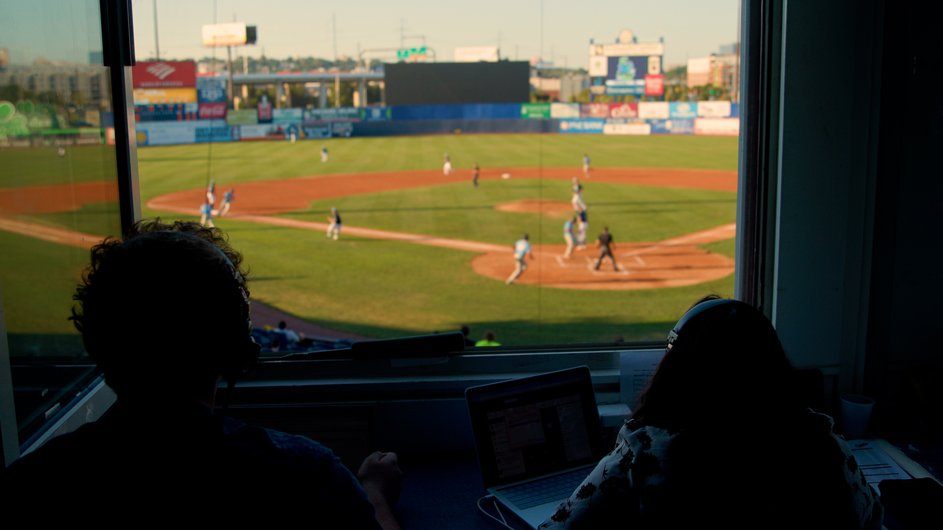 A wideshot looking out onto a stadium with two rowan broadcasters.