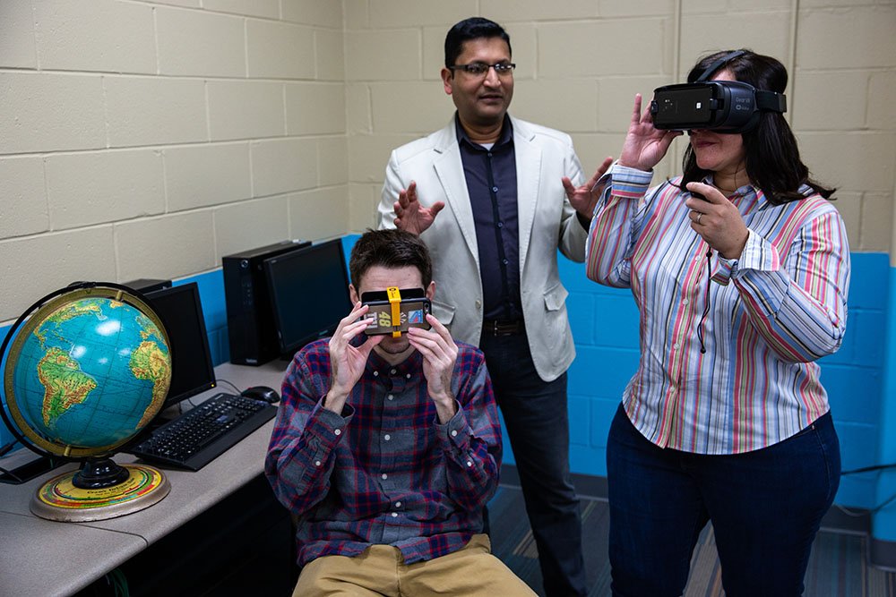 Faculty member and students experimenting with virtual reality