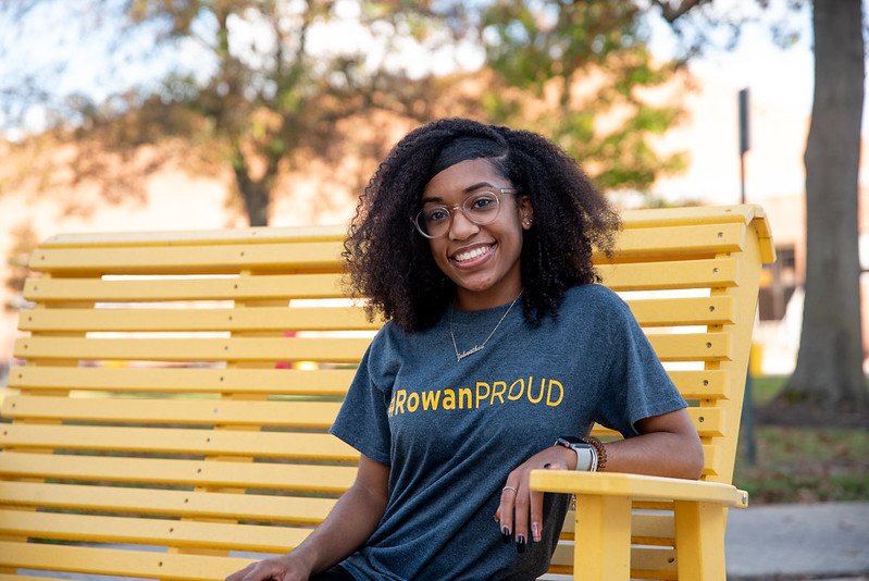 girl in a #RowanPROUD t-shirt sitting on a bench