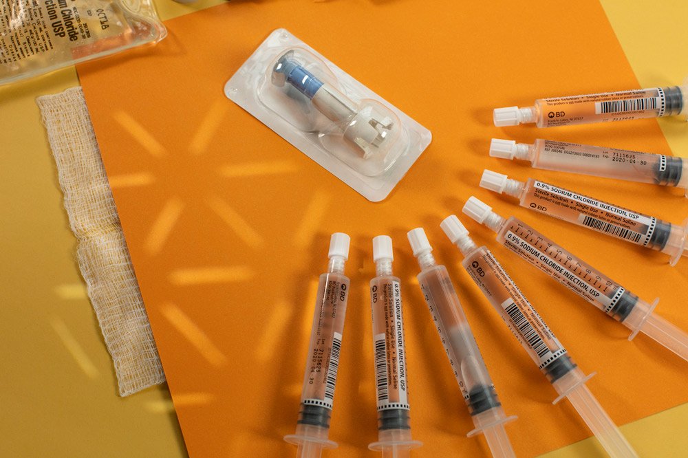A close up photo of syringes and medical bags