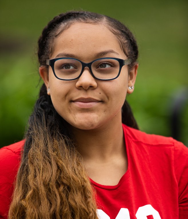 a close up portrait of a student in a red shirt