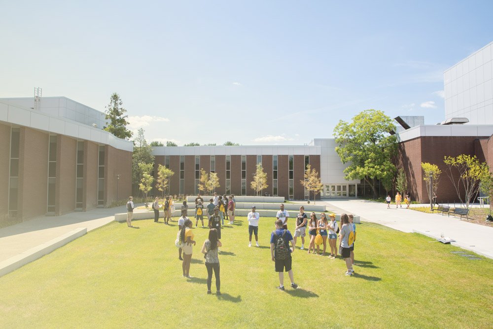 Students stand in a circle in front of Wilson Hall.