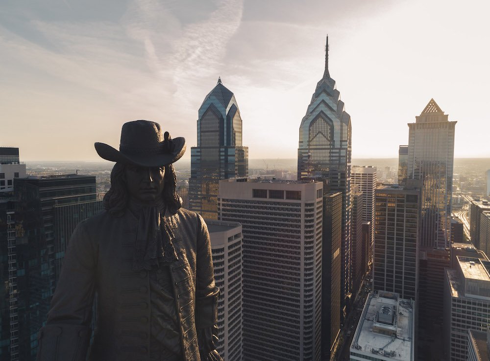 Drone shot of William Penn statue and skyscrapers in background. 
