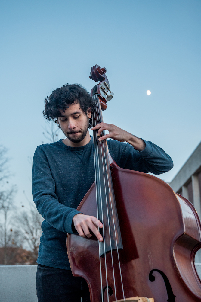 Rafael plays cello outside Wilson Hall.