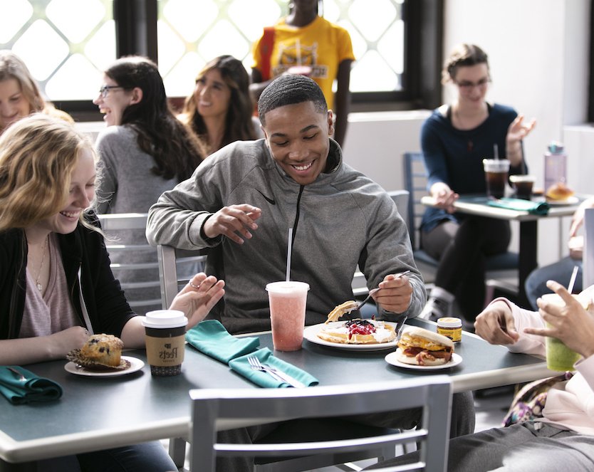 Three students sharing a laugh over waffles