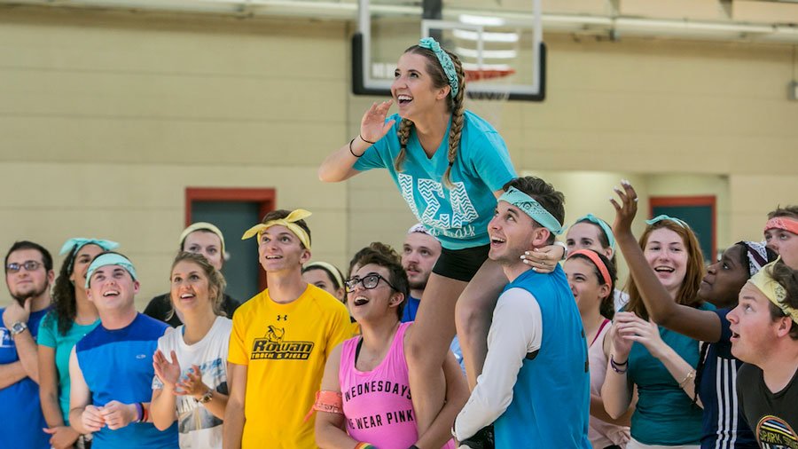 A group of students in brightly colored tee's in the rec center gym
