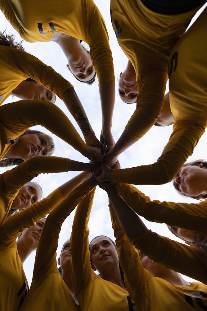 A Rowan University team joins for a huddle.