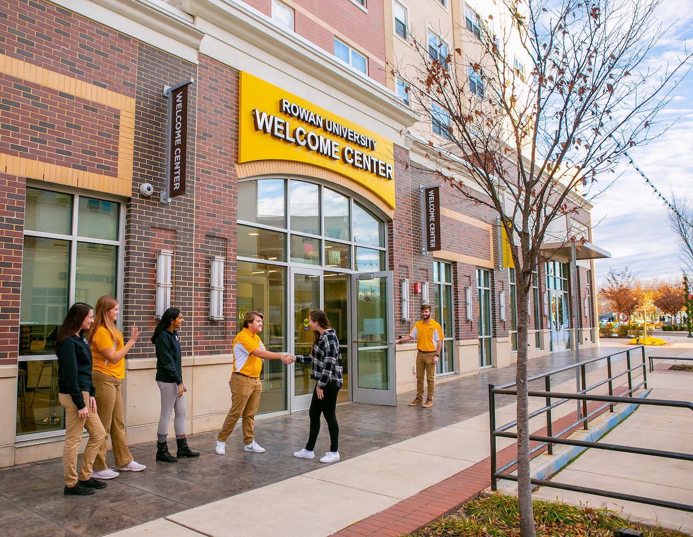 An image of Rowan University's Welcome Center with students outside.
