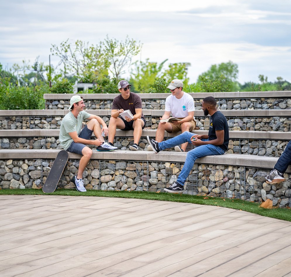 A group of Rowan students sitting on gabion wall steps.