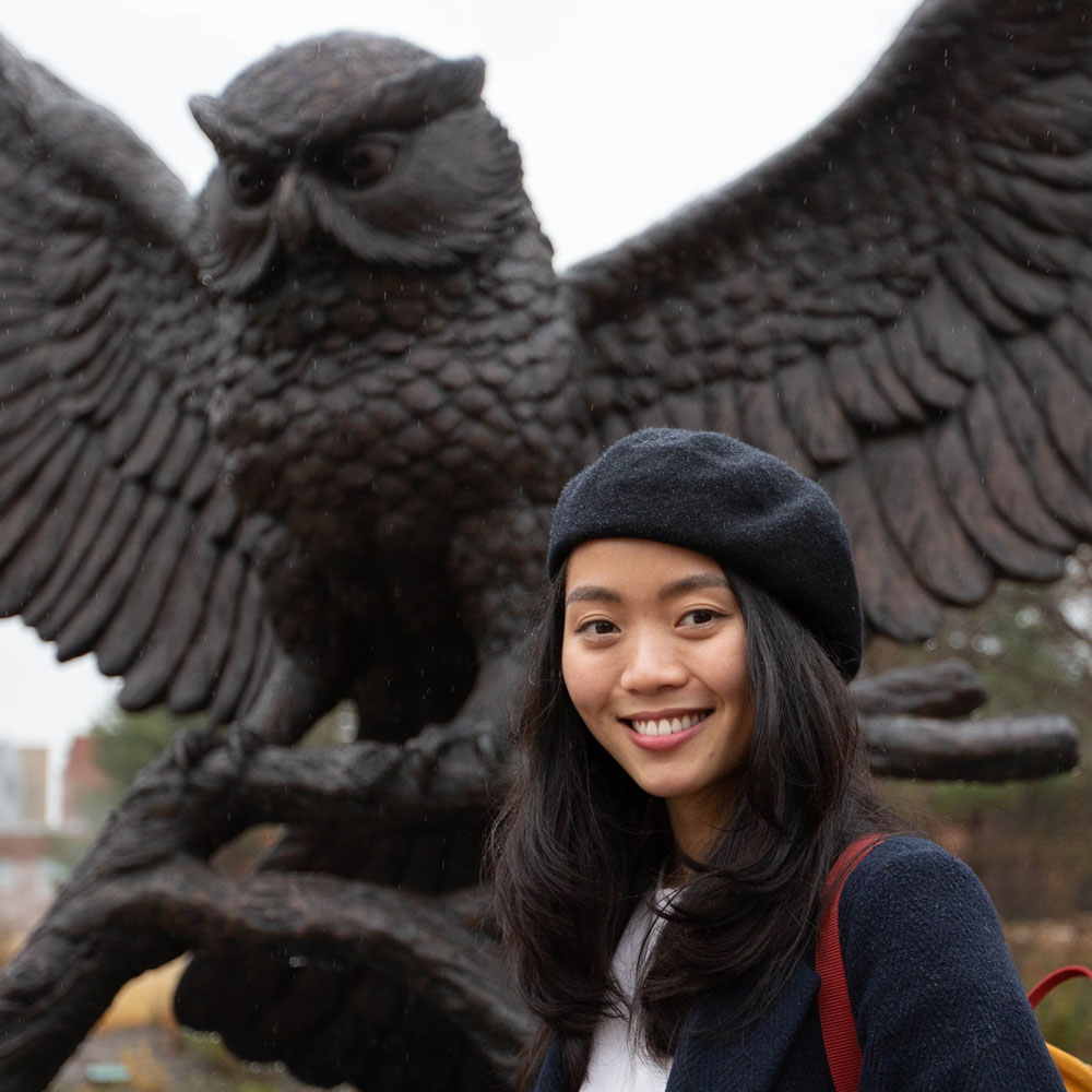 Nam stands in front of the Rowan owl statue.
